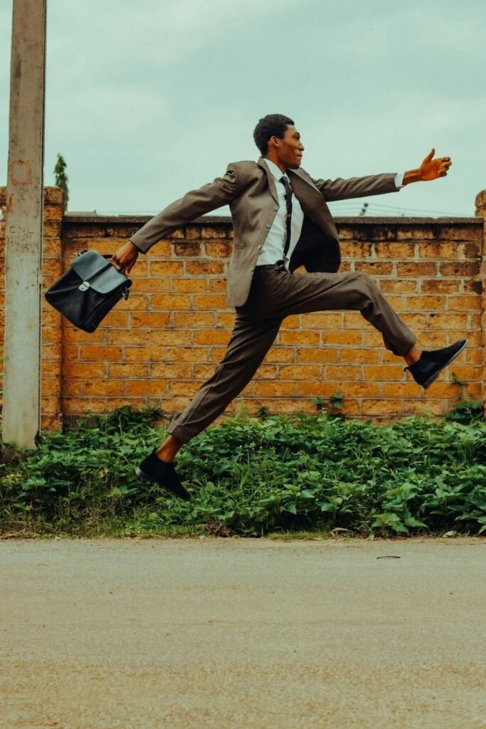 Homme ambitieux qui marche droit devant lui vers la droite, en tenant une mallette professionnelle dans sa main droite.
